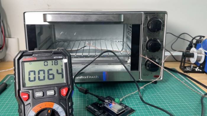 Checking the temperature probe against a multimeter, with the controller board in front of the oven