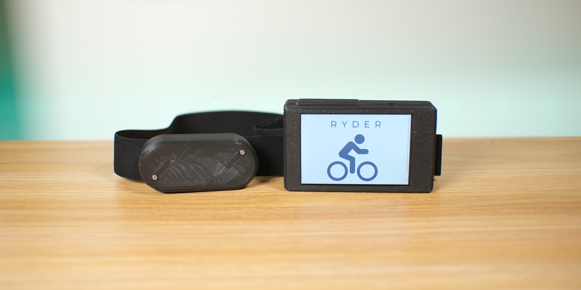 The Ryder handlebar unit and ECG chest strap on a table