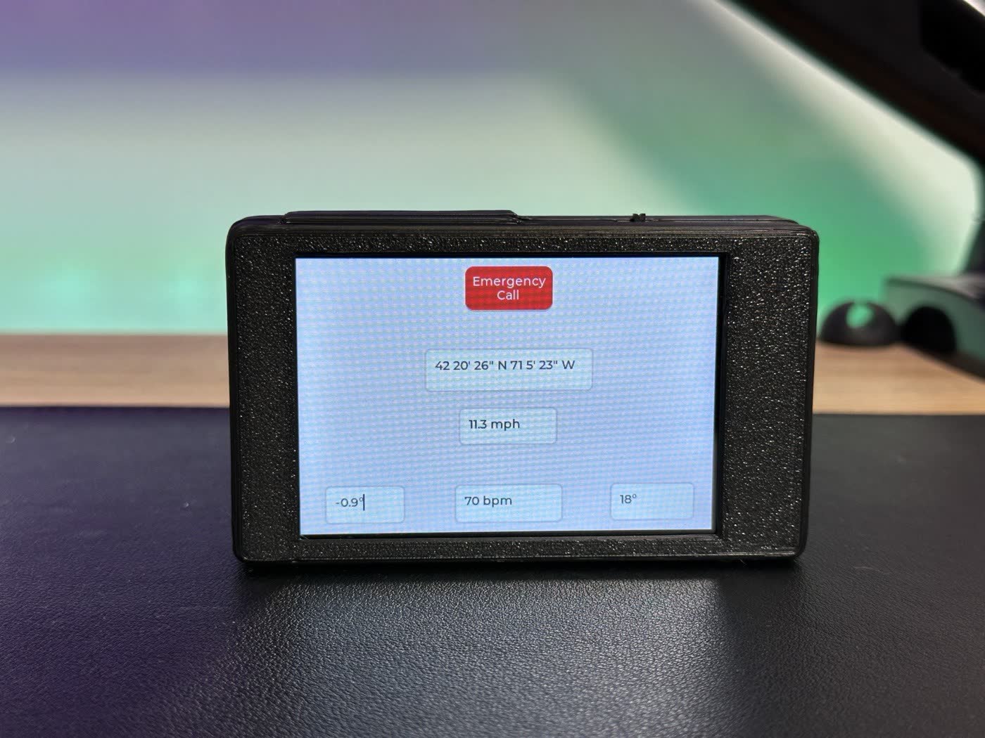 Handlebar unit with touchscreen showing GPS coordinates, 11.3 mph, 70 bpm and an Emergency Call button